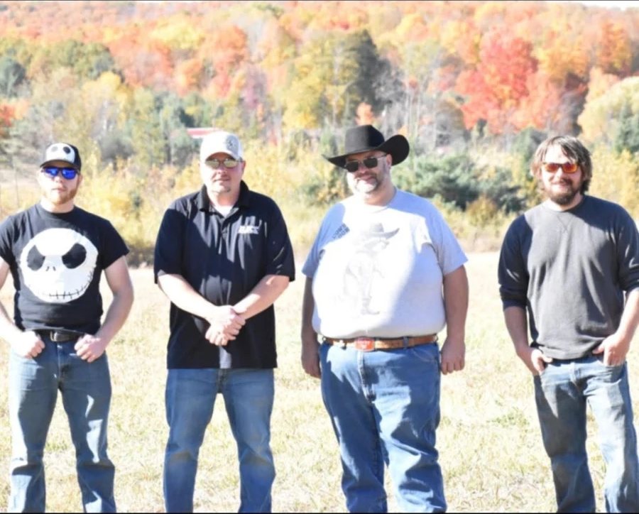 The Side Hicks standing in a field with fall colors behind them