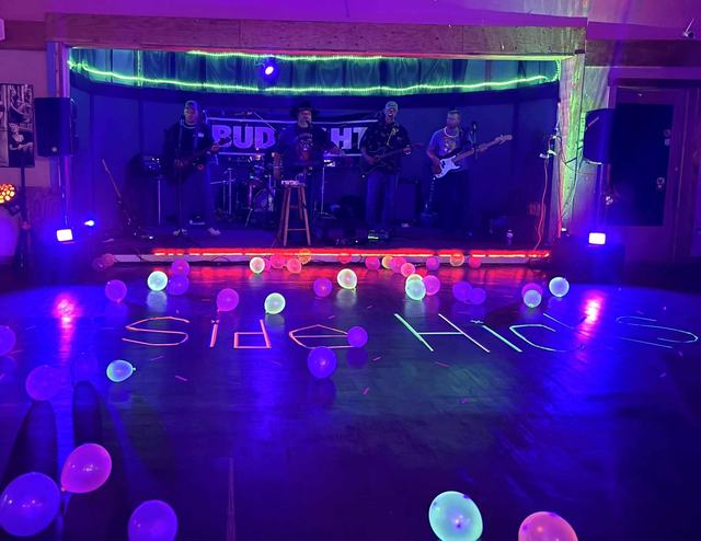 Blacklight night: our name glowing on the dance floor